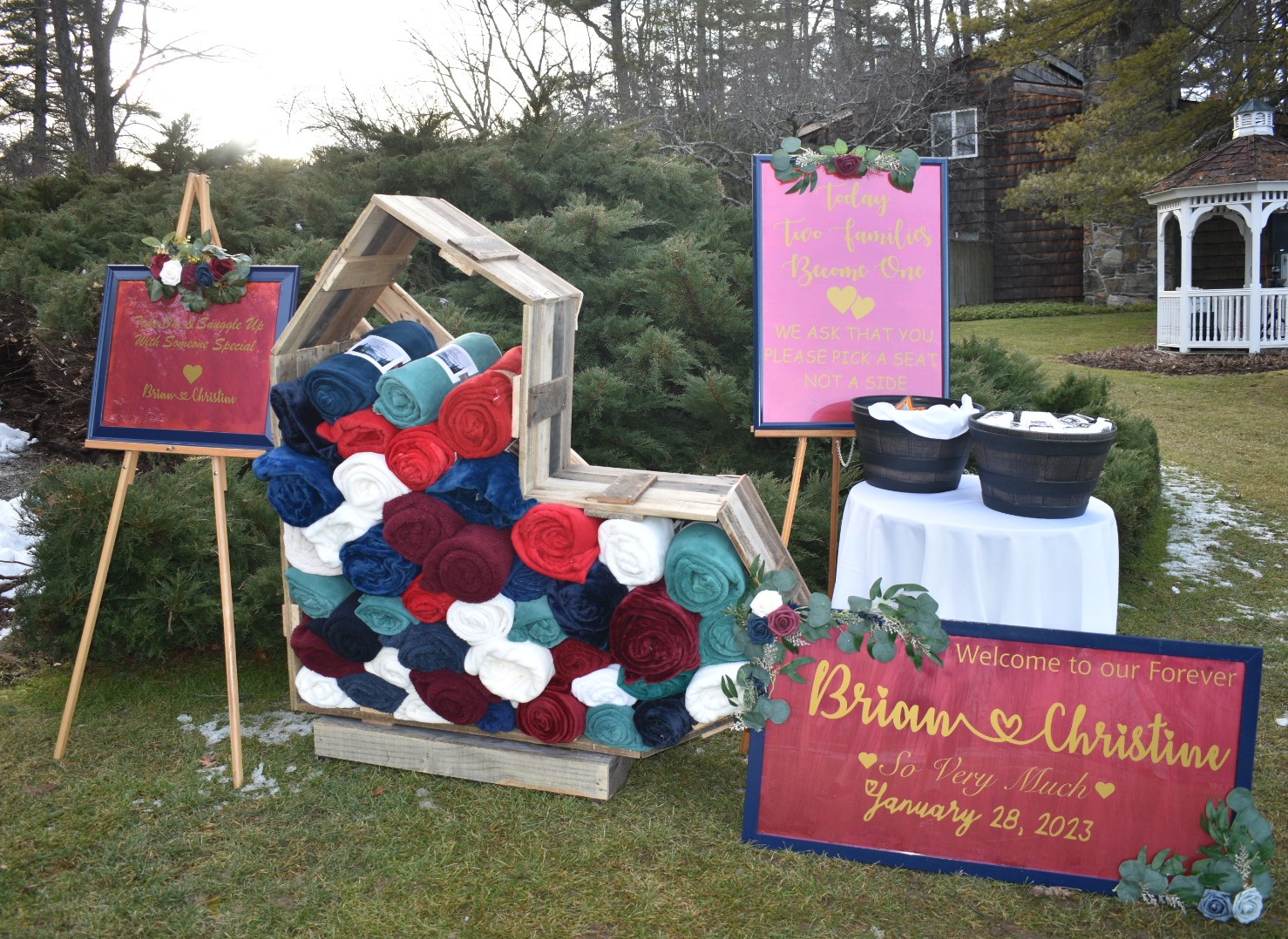 pallet wood ceremony signs with a stack of fleece blankets individually rolled