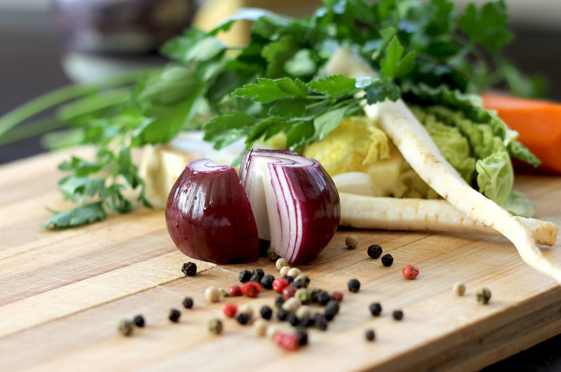 onion and peppercorns on a cutting board