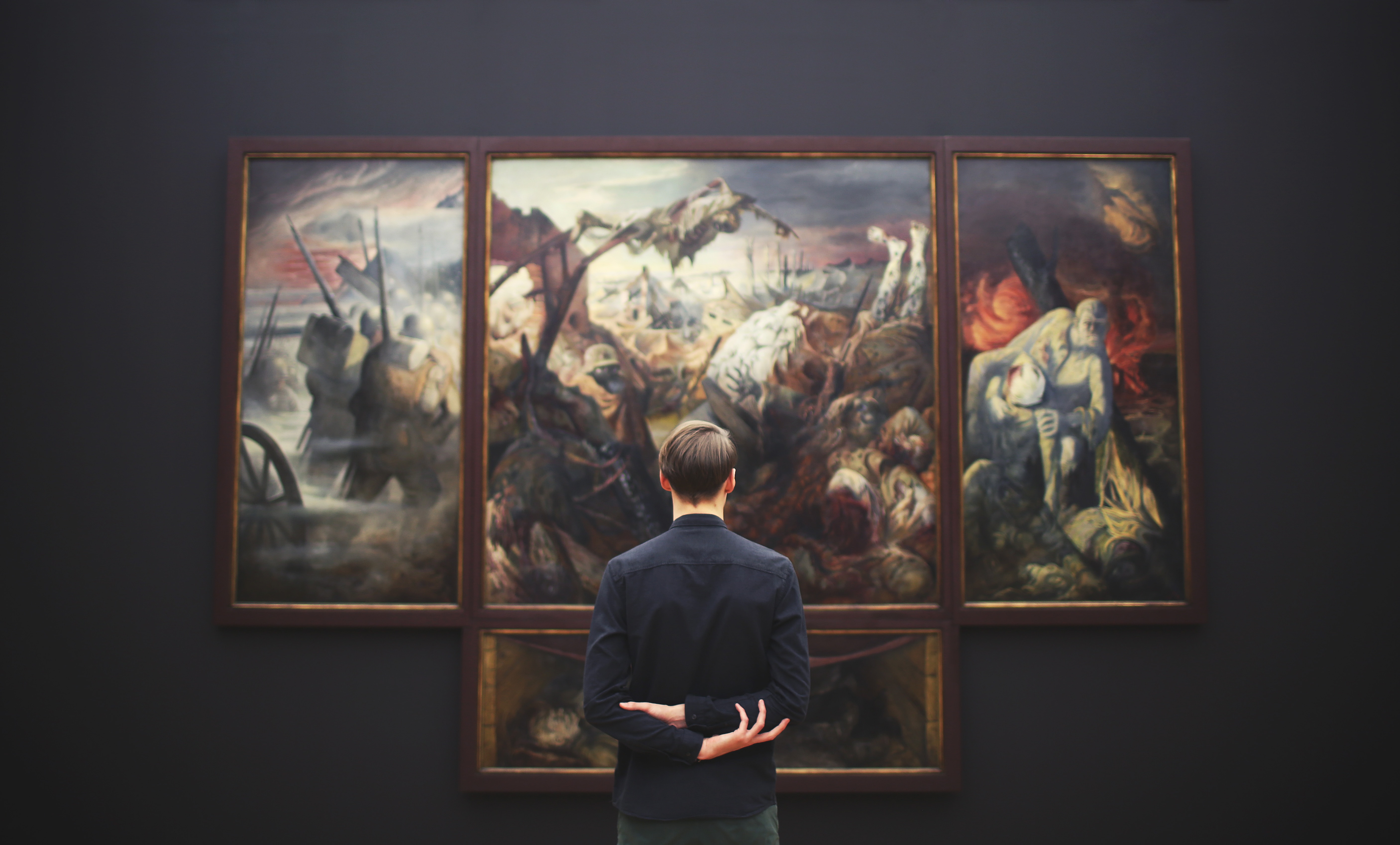 person standing looking at a painting