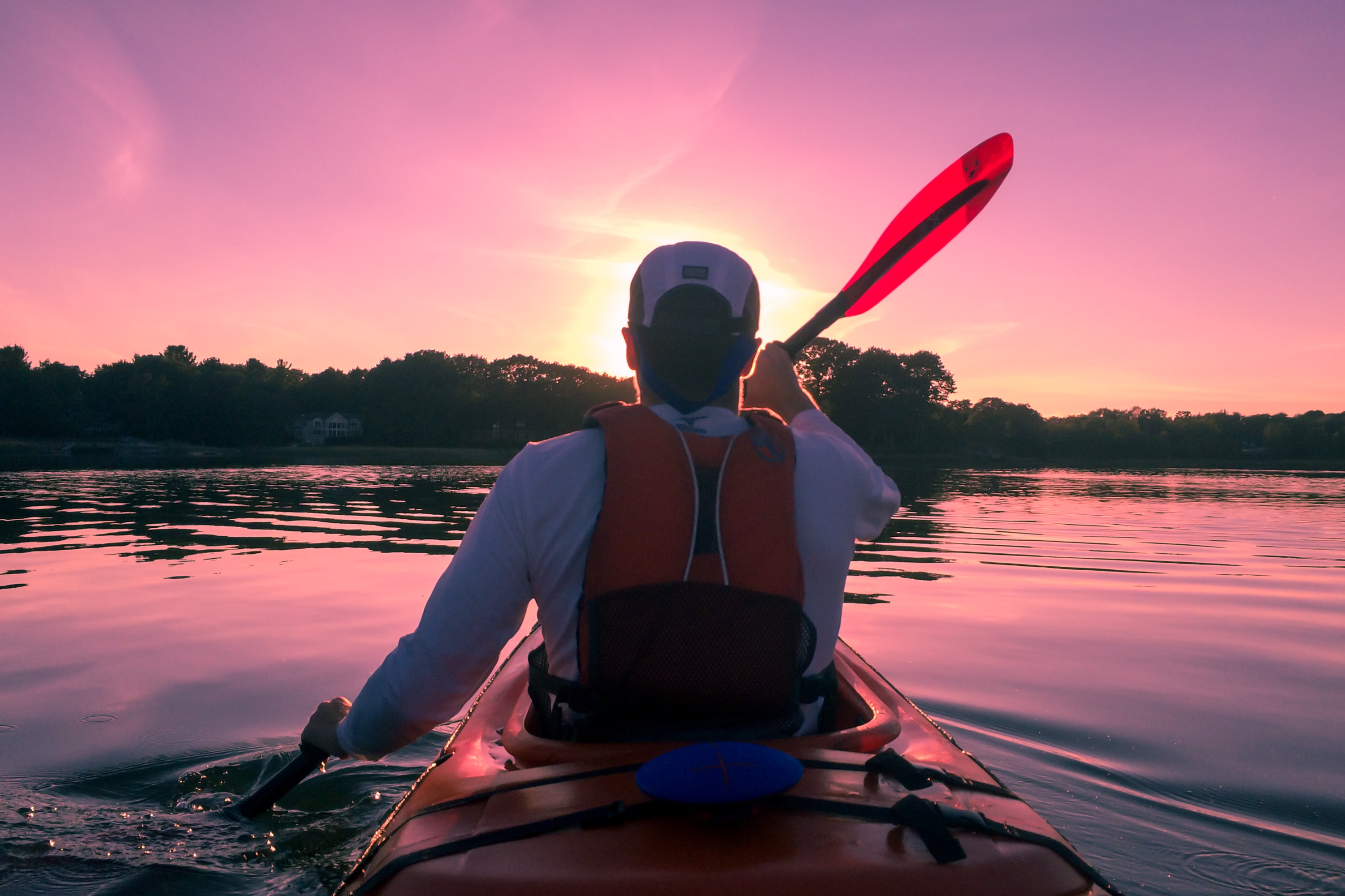 person kayaking at sunrise